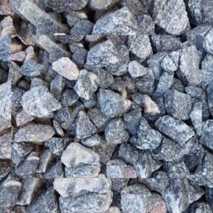 A close-up view of a pile of small, rough gray stones, showcasing various textures and irregular shapes, arranged in a loose, natural pattern.