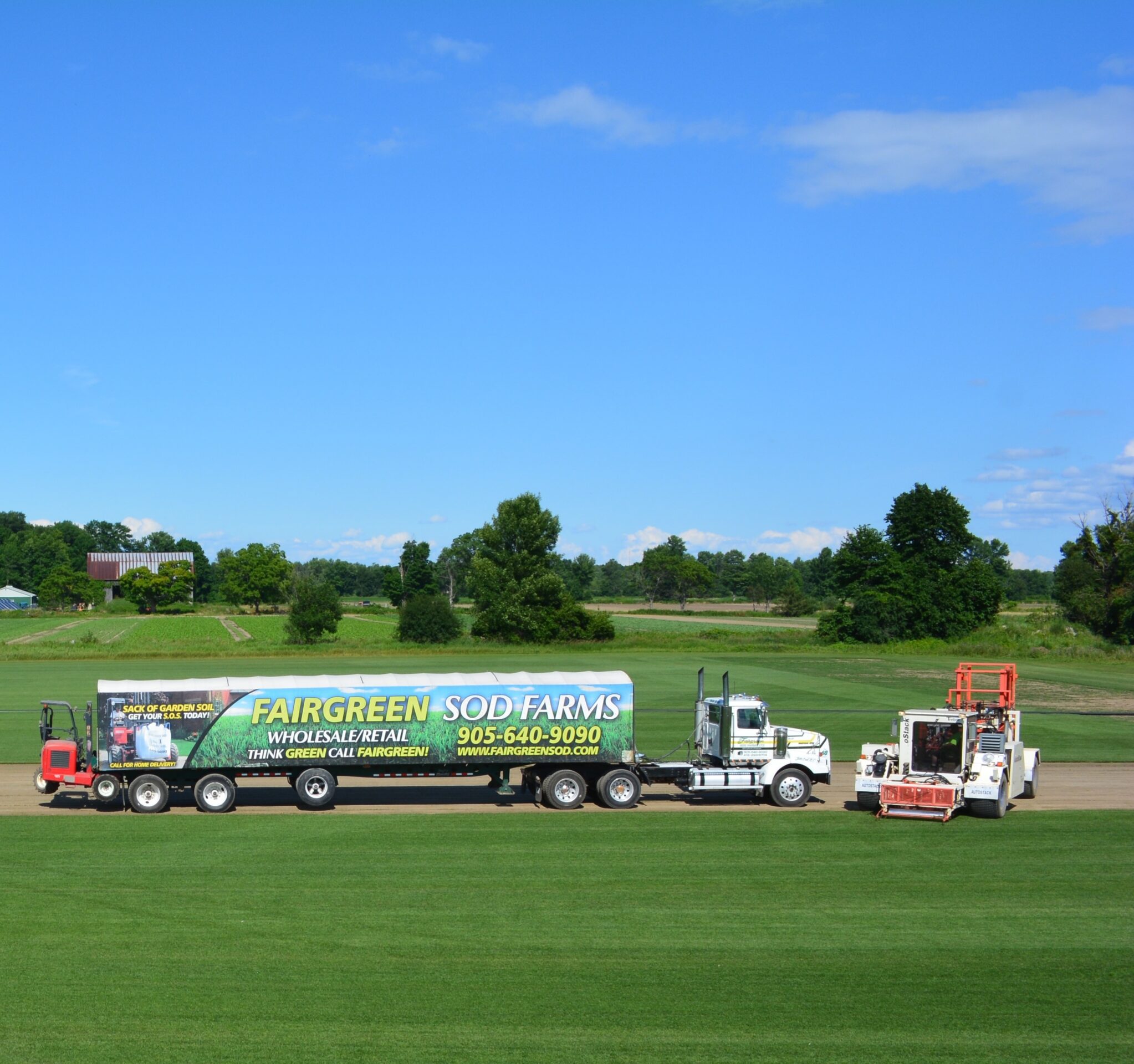 A truck labeled "Fairgreen Sod Farms" is parked on a lush, green farm with clear skies and trees in the background.